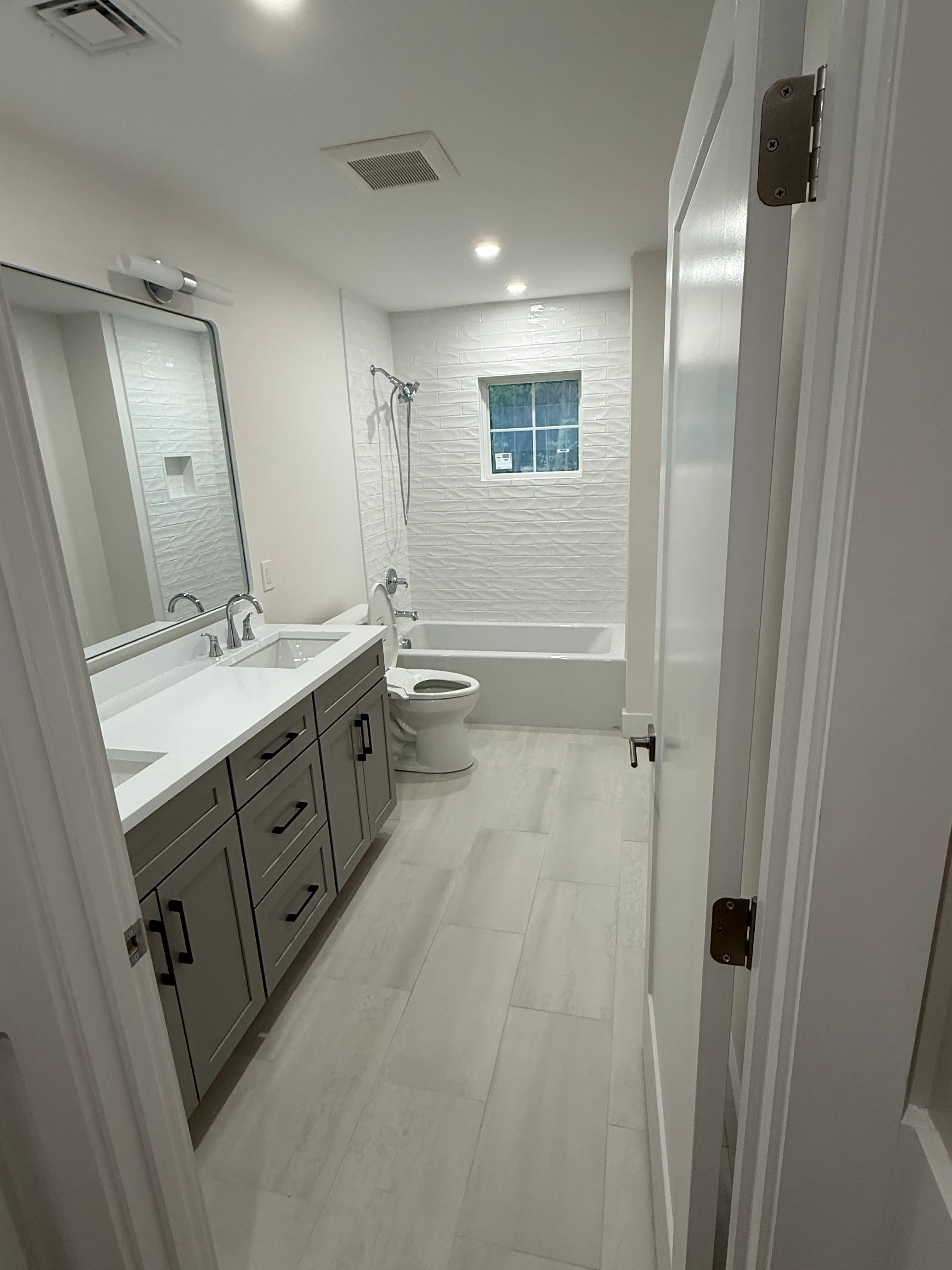 Marble vanity with dual sinks and vertical-textured tile wall