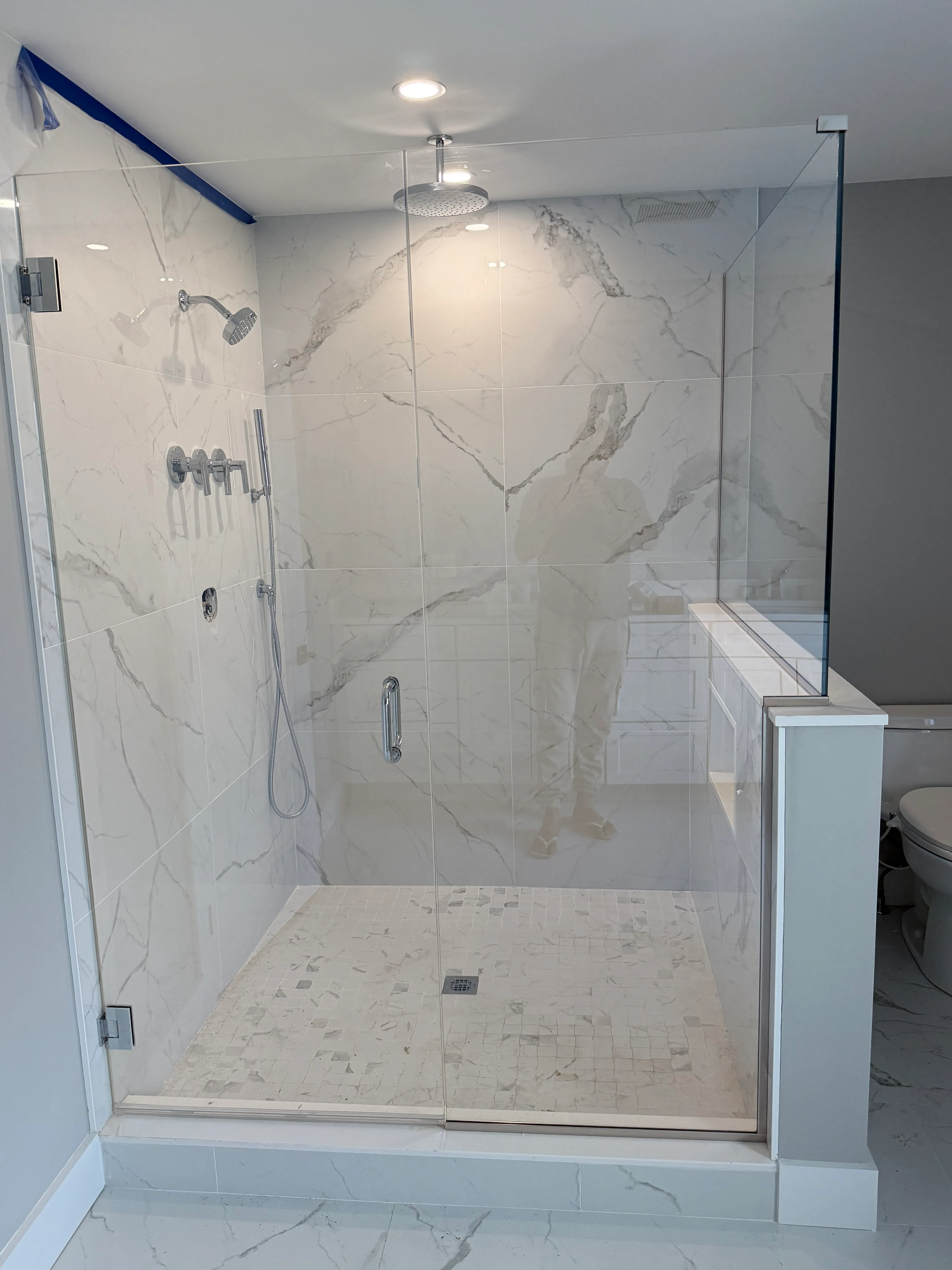 Same marble shower as the opening clip — frameless glass enclosure
