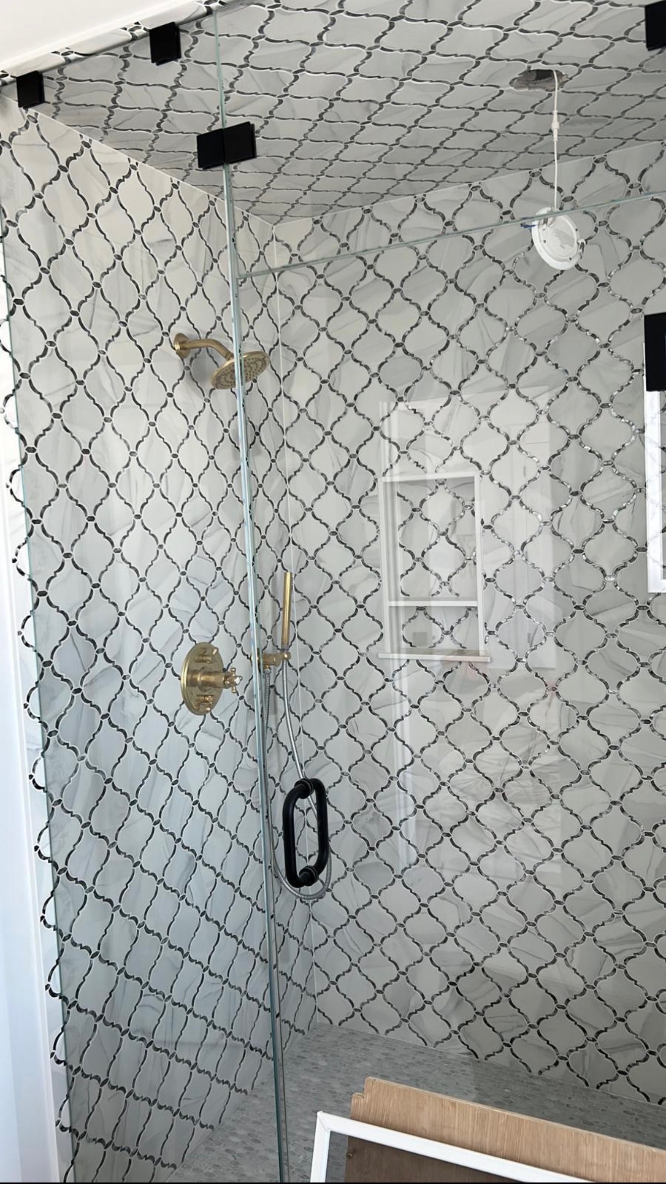 Detailed arabesque tile work close-up with brass fixtures showing precision craftsmanship