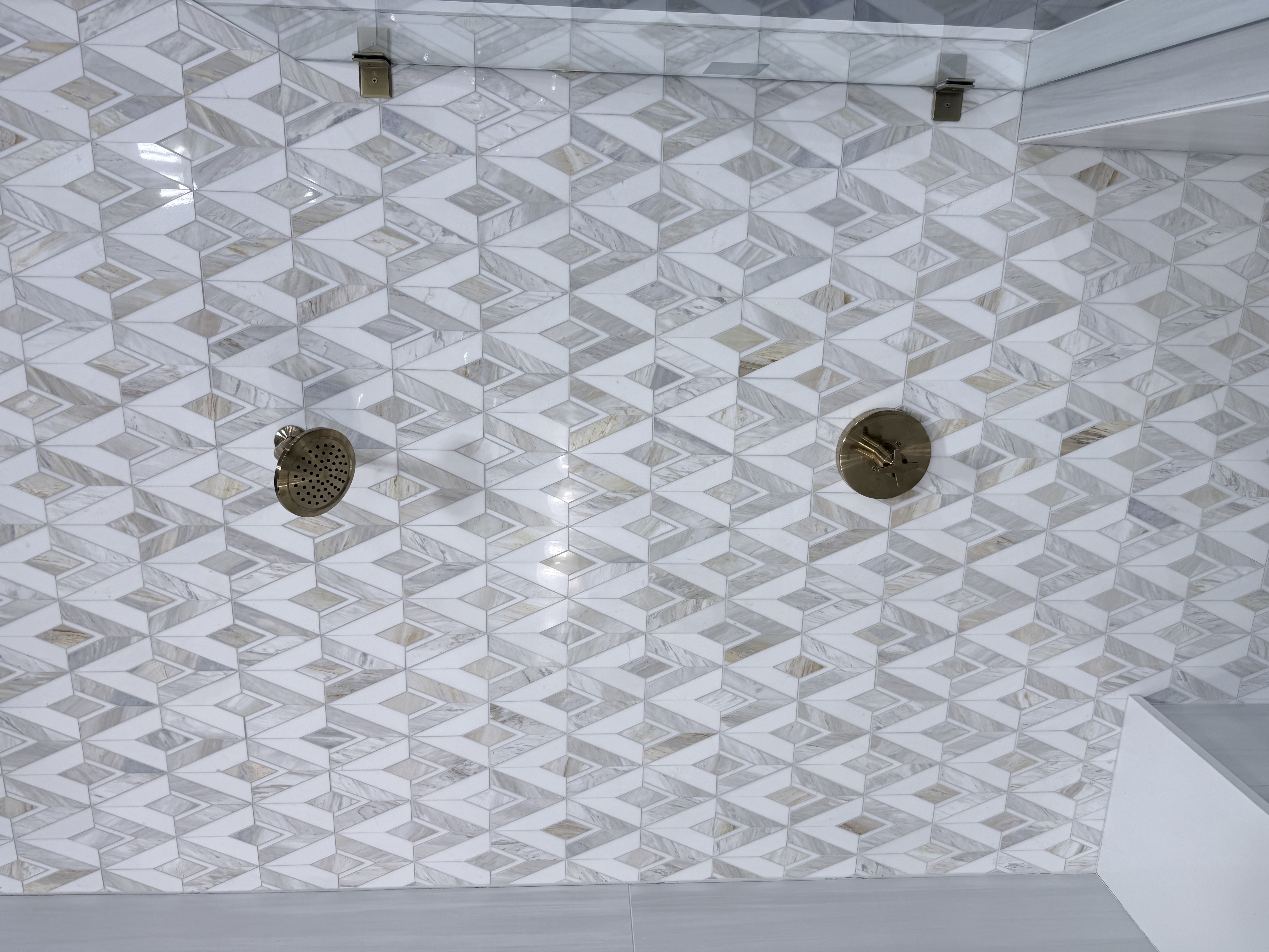 Geometric marble mosaic with dual brass rain shower heads